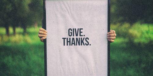 person holding 'give thanks' sign | Readable, free readability test