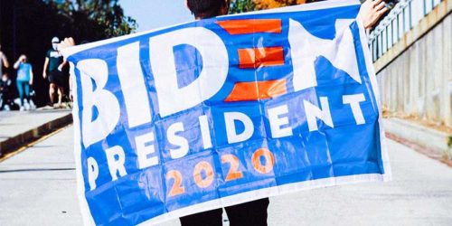 Man holds 'Biden President 2020' flag across his back | Readable, free readability test