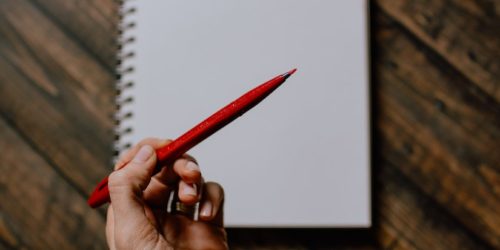 Blank sheet of paper and red pen