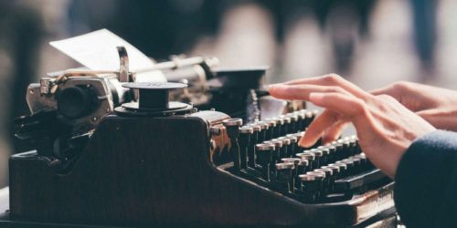 Someone typing on an old fashioned typewriter