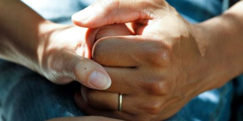 Two people holding hands in a crew setting